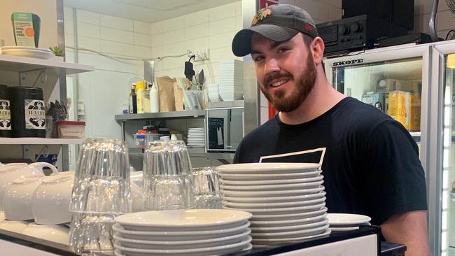 An exhausted Marcus Cutler back working in his parents cafe at Manly after his endurance test on Saturday Pic: Supplied