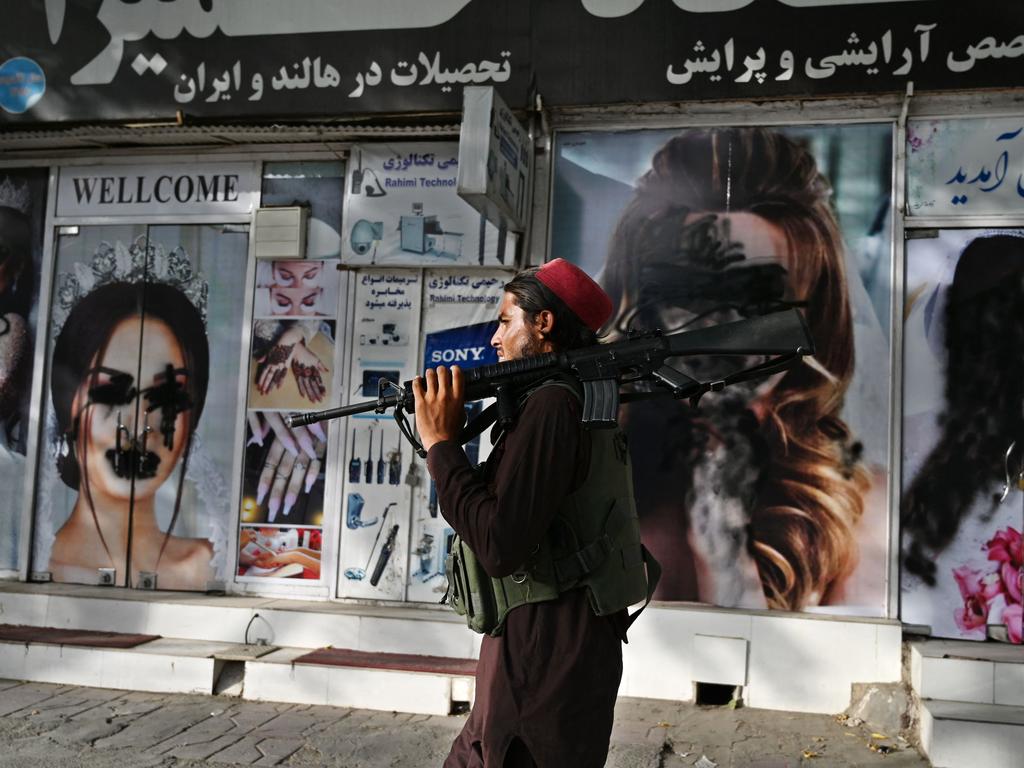 Images of women were defaced with black spray paint. Picture: Wakil Kohsar/AFP