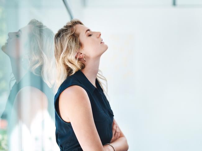 Shot of a young businesswoman looking stressed out in an office