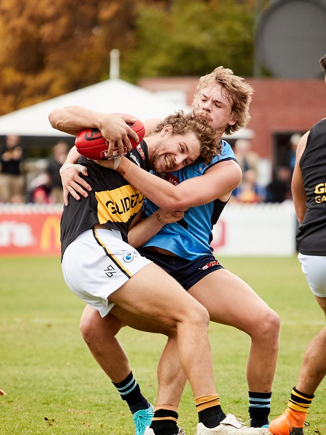 Glenelg’s Matt Snook gets tackled by Sturt’s Henry Carey on Saturday. Picture: AAP/Matt Loxton.