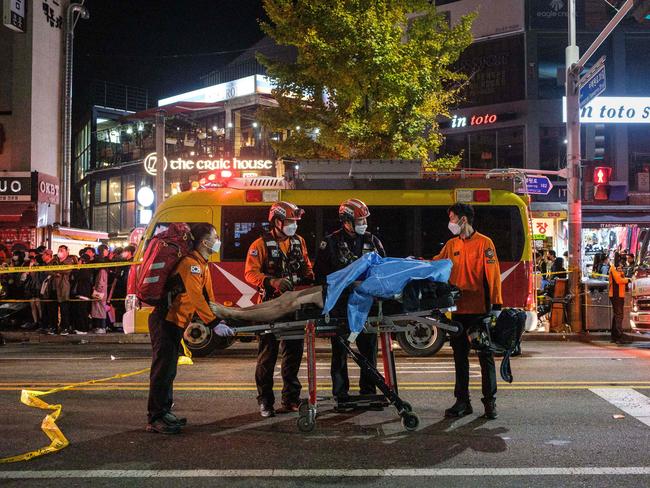 Emergency workers standing beside a stretcher with the body of a victim of a Halloween stampede in the district of Itaewon in Seoul. Picture: AFP