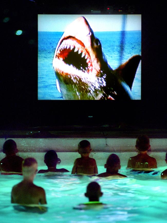 Youngsters watch a scene from Jaws at a ’dive-in movie’ at a municipal pool in the US. Picture Hays/Daily/News, Charlie/Riedel/ AP