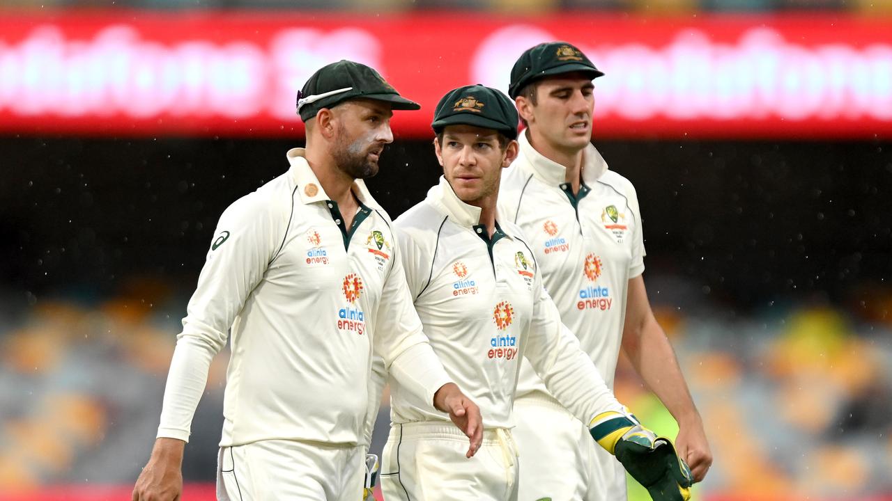 BRISBANE, AUSTRALIA - JANUARY 18: Tim Paine, Nathan Lyon and Pat Cummins of Australia are seen leaving the field as a rain delay is called during day four of the 4th Test Match in the series between Australia and India at The Gabba on January 18, 2021 in Brisbane, Australia. (Photo by Bradley Kanaris/Getty Images)