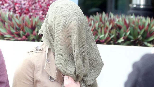 Erin Smitheram conceals her face as she enters Southport Magistrates Court where she pleaded guilty for drink driving. Picture: Richard Gosling