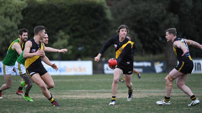 Michael Barro (centre) of Mitcham gets off a handball in the Tigers’ EFL match against Bayswater at Walker Park, Nunawading.