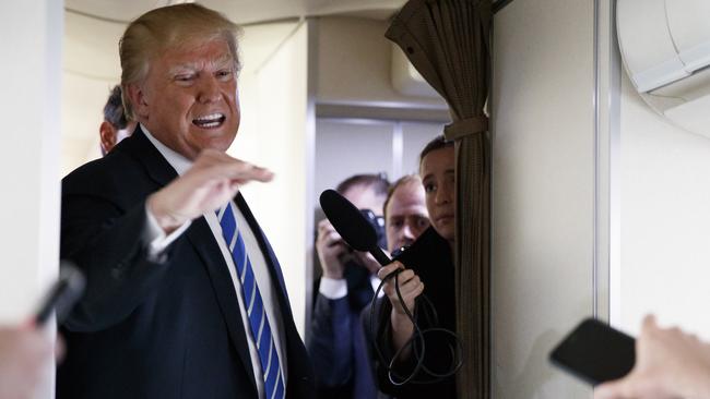 President Donald Trump talks with reporters aboard Air Force One on a flight to Andrews Air Force Base, Thursday. Pic: AP Photo/Evan Vucci.