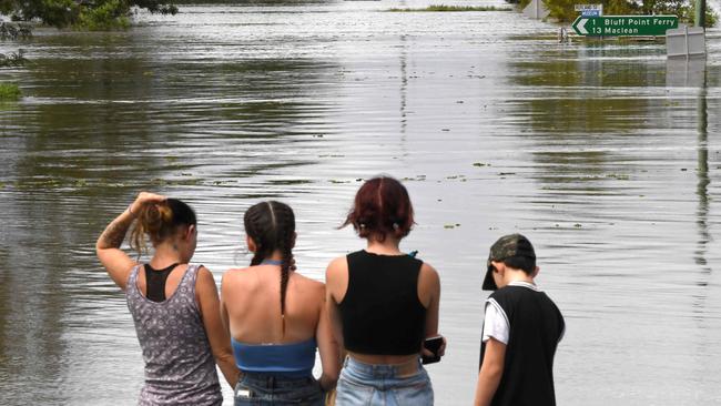 Residents stand by a flooded street in Lawrence, near Maclean, on March 1, 2022. Picture: Saeed Khan.