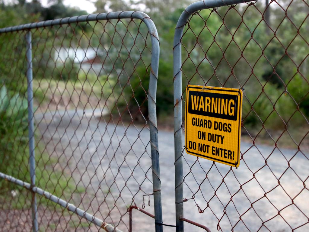 A sign on the fence of the property reads: “Guard dogs on duty. Do not enter!” Picture: David Clark