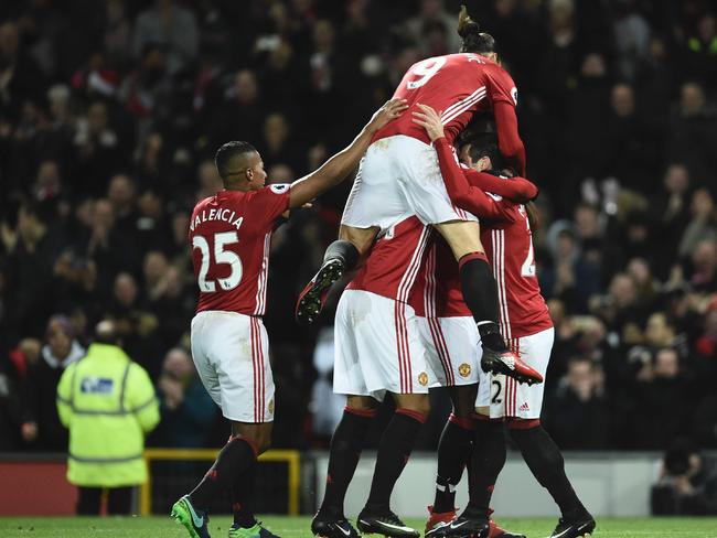 Manchester United's Swedish striker Zlatan Ibrahimovic (C) jumps into the celebration.