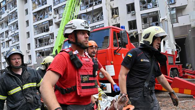 Ukrainian rescuers carry wounded Russian citizen Ekaterina Volkova from a residential building destroyed by Russian missiles in Kyiv. Picture: Sergei Supinsky / AFP)