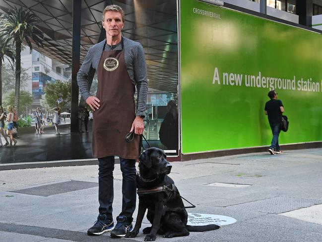 Gerrard Gosens with his duide dog Boss outside the site for the Albert Street Cross River Rail station. Picture: AAP/John Gas