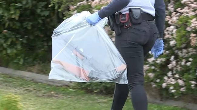 Police remove a gun from one of the addresses. Picture: Police Media