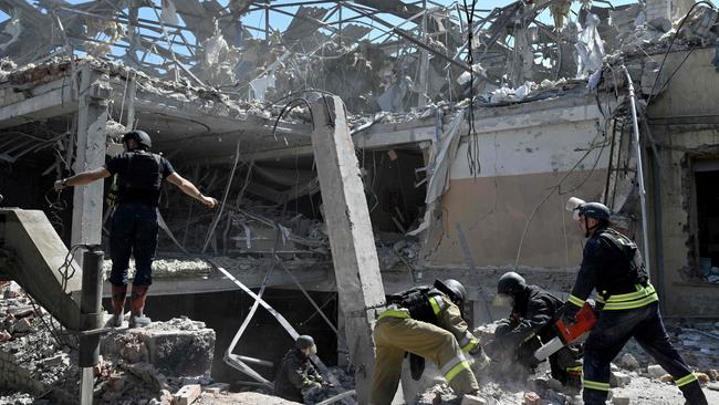 TOPSHOT - Ukrainian emergency services carry out a search and rescue operation among the rubble of a destroyed hotel after a strike in the town of Kramatorsk, Donetsk region on August 25, 2024. A member of the Reuters news agency was missing and two others were wounded in a Russian strike on a hotel in the east Ukrainian city of Kramatorsk, the agency said. A search and rescue operation was underway at the Hotel Sapphire, where Reuters said six of its crew covering the war, were staying. (Photo by Genya SAVILOV / AFP)