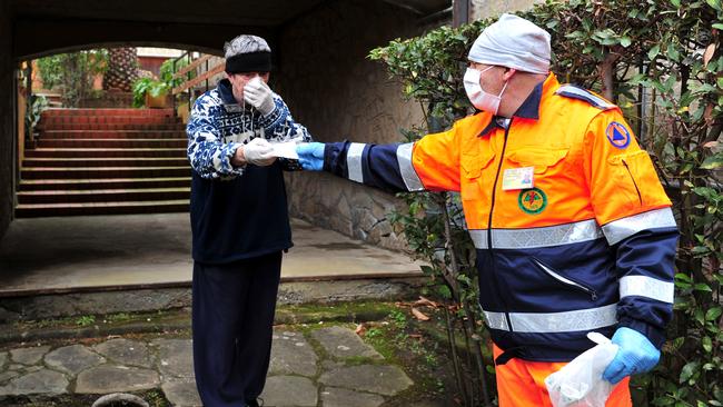 A volunteer hands a mask to a man in the Tuscan town of Castiglione della Pescaia, Italy. Picture: AP