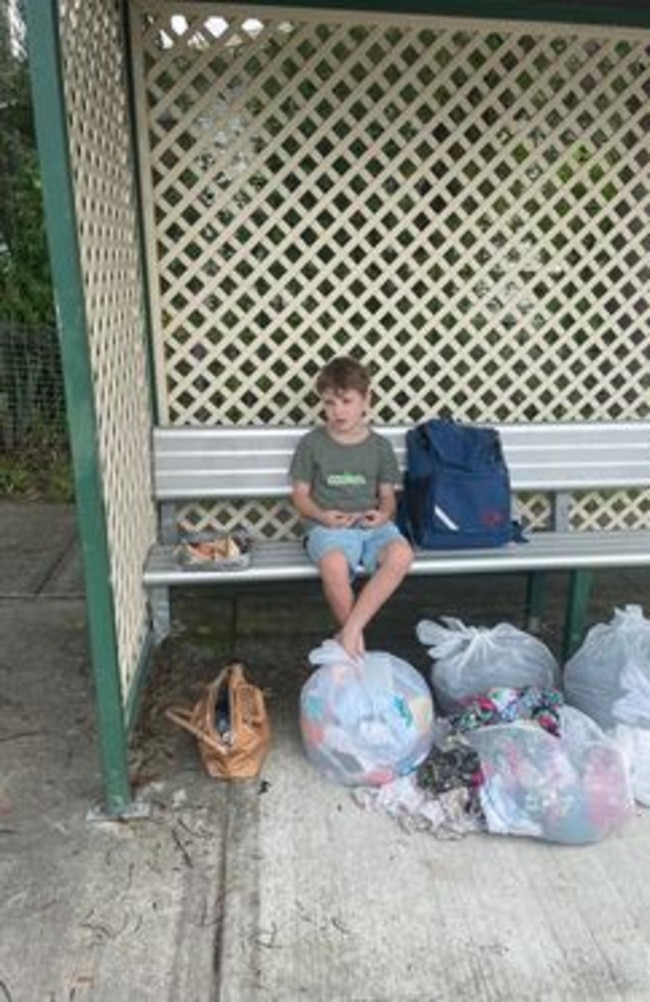 Archer sits at a bus stop on Monday after being forced to flee from his home because of the flood.