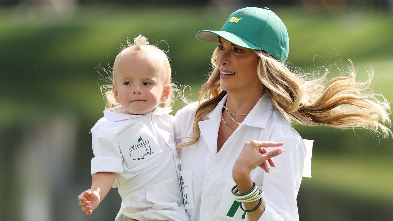 Wife of Brooks Koepka Jena Sims, carries their son, Crew Sims Koepka prior to the 2025 Masters. Photo by Richard HEATHCOTE / GETTY IMAGES.