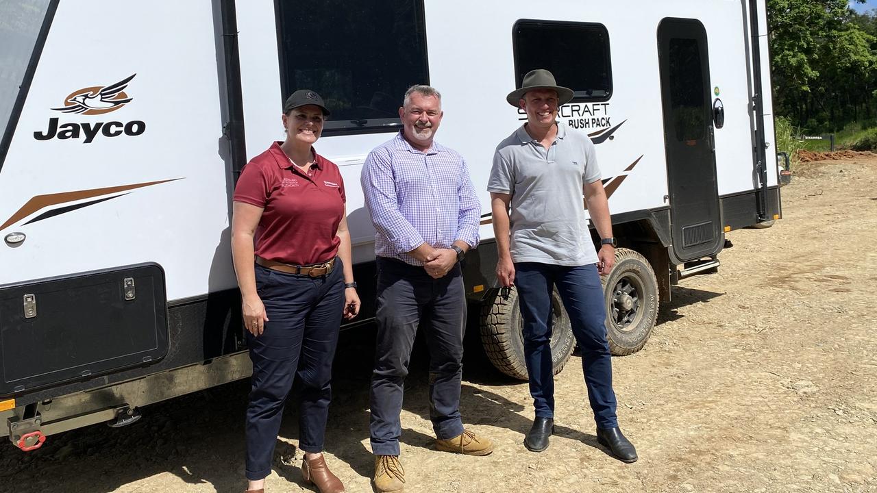 Disaster Recovery Minister, Nikki Boyd, Douglas Shire mayor Michael Kerr and Premier Steven Miles with a caravan that has been deployed to Degarra for flood victims to use more than a month after the record rain event.