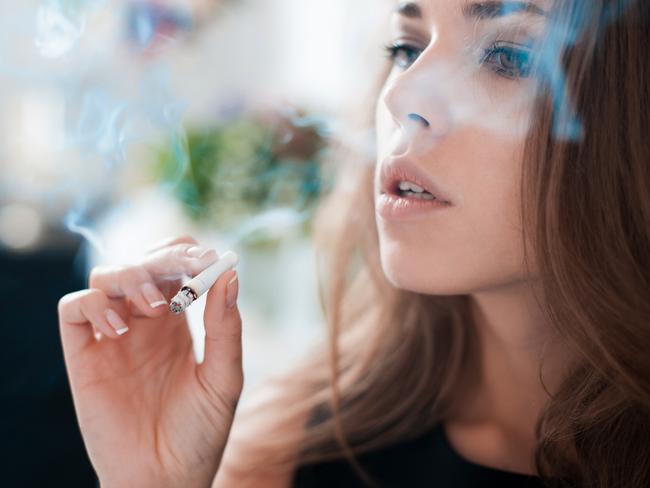 The thoughtful woman smokes a cigarette.