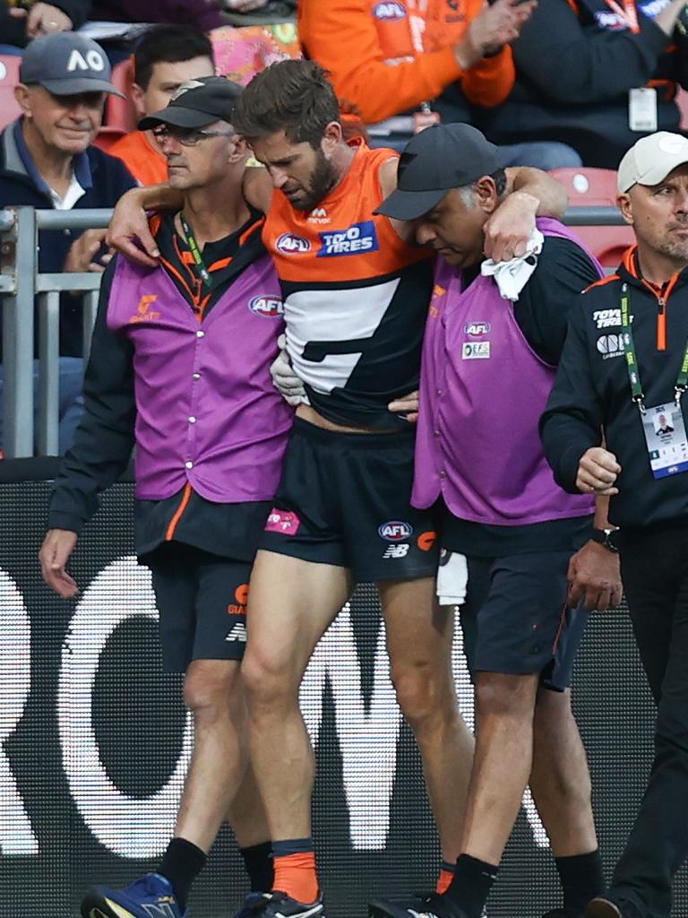 Callan Ward is helped from the field after injuring his knee.