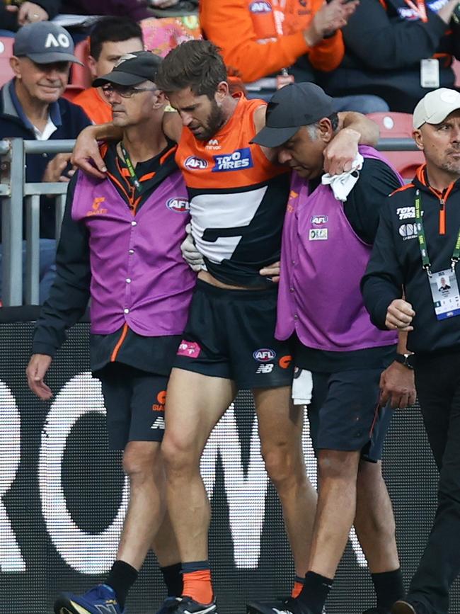 Callan Ward is helped from the field after injuring his knee.