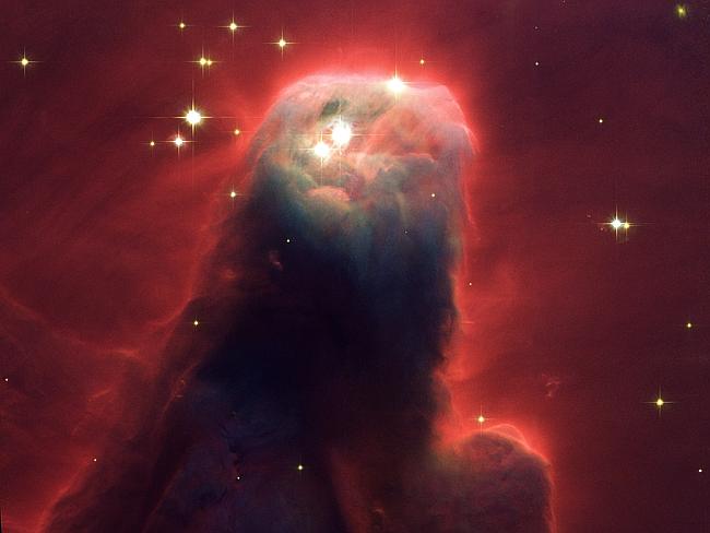 Resembling a nightmarish beast rearing its head from a crimson sea, this celestial object is actually just a pillar of gas and dust. Called the Cone Nebula (in NGC 2264)