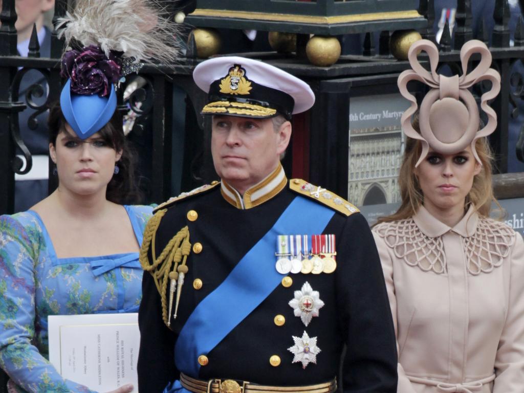 Eugenie and Beatrice (in her infamous hat) with father Prince Andrew. Picture: AP Photo/Gero Breloer