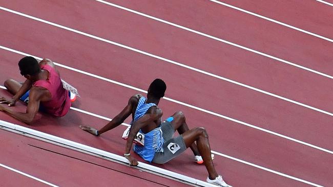 USA's Isaiah Jewett (L) and Botswana's Nijel Amos react after falling on the track while competing in the men's 800m semi-finals during the Tokyo 2020 Olympic Games at the Olympic Stadium in Tokyo on August 1, 2021. (Photo by Antonin THUILLIER / AFP)