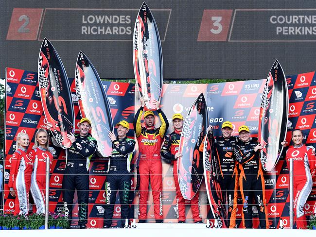 First-placed winners Supercheap Auto Racing drivers Chaz Mostert and co-driver James Moffat (centre) are seen on the podium with second-placed winners Autobarn Lowdnes Racing drivers Craig Lowdnes and Steven Richards (left) and third-placed winners Mobil 1 Boost Mobil Racing drivers James Courtney and Jack Perkins (right) during a trophy presentation following Race 26 of the 2018 Virgin Australia Supercars Championship at the Vodafone Gold Coast 600 on the Surfers Paradise street circuit on the Gold Coast, Saturday, October 20, 2018. (AAP Image/Dave Hunt