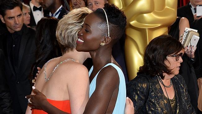 Jennifer Lawrence and Oscar winner Lupita Nyong'o embrace at the Oscars. 