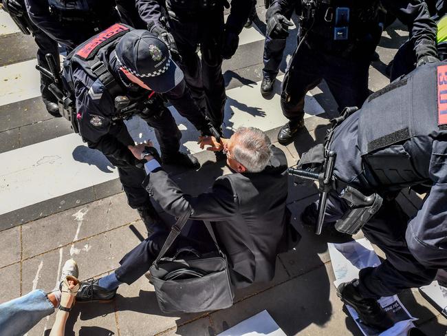 A man is knocked to the ground during the protest at the IMARC conference. Picture: Jake Nowakowski