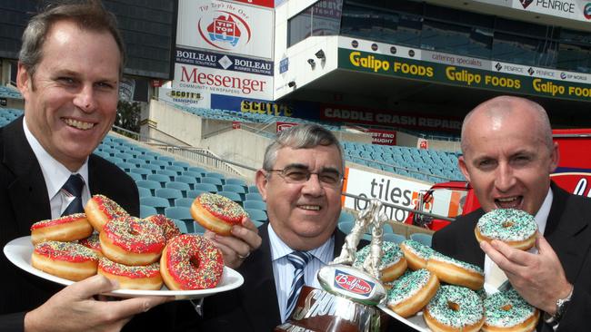 Adelaide Crows chief executive Steven Trigg,  with Balfours' SA general manager Darryl Pritchard and Port Adelaide's chief executive John James holding trays of donuts at the launch of the Balfours Showdown at AAMI Stadium. 