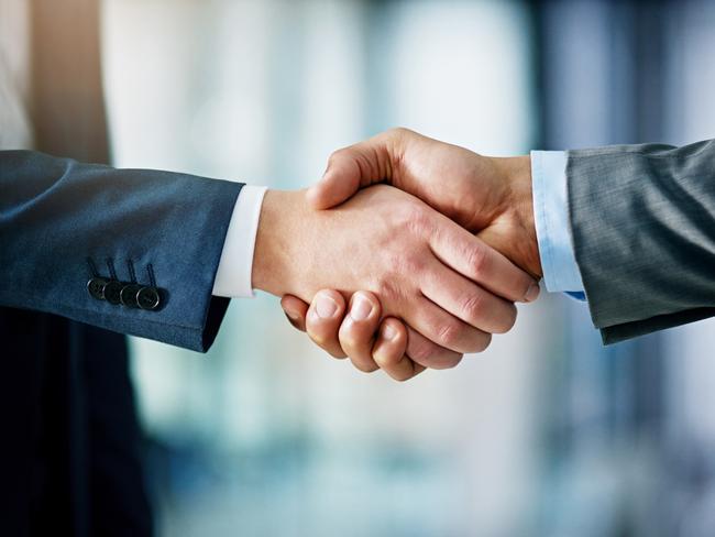 Closeup shot of two businessmen shaking hands in an office