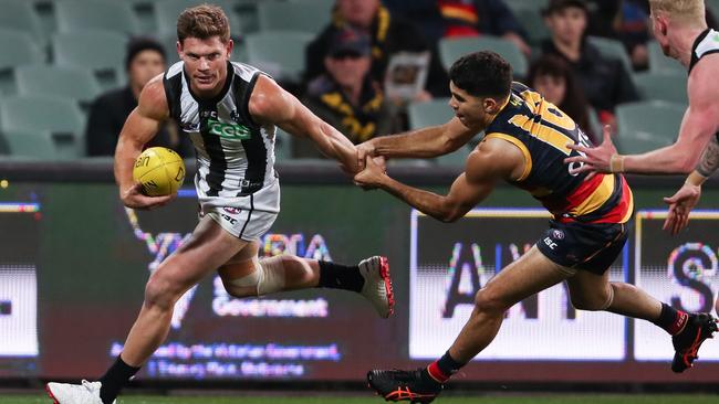 Magpie Taylor Adams is tackled by Tyson Stengle at Adelaide Oval Picture: Getty Images