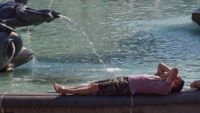 A Londoner lays down next to the fountain at Trafalgar Square in an attempt to cool down. Picture: Vuk Valcic/SOPA Images/LightRocket via Getty
