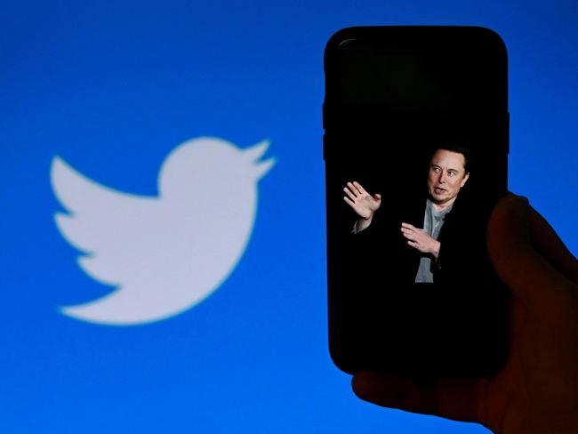 (FILES) In this file photo taken on October 04, 2022, an illustration photo shows a phone screen displaying a photo of Elon Musk with the Twitter logo shown in the background, in Washington, DC. - Twitter boss Elon Musk announced in a series of tweets on January 21, 2023, that the company's subscription service would show less advertising to users, including an ad-free tier. (Photo by OLIVIER DOULIERY / AFP)