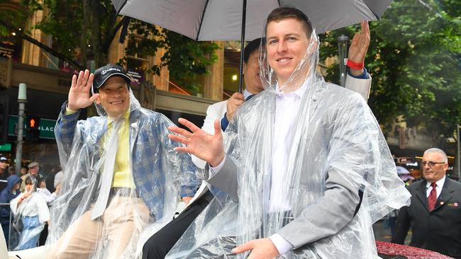 Mer De Glace’s trainer Hisashi Shimizu, left, and jockey Damian Lane brave a downpour during the Melbourne Cup Parade. Picture: AAP