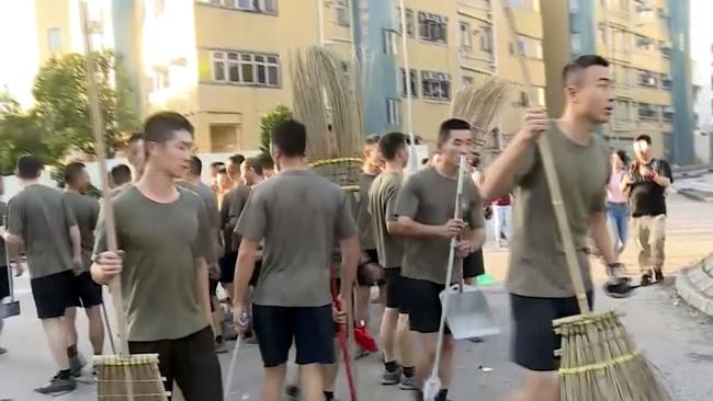 People’s Liberation Army soldiers, with brooms, arrive to clean up the protest area at Hong Kong Baptist University in Hong Kong. Picture: AP