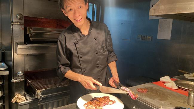 The head chef at the Beijing outpost of America-themed steakhouse “Morton’s of Chicago” prepares a porterhouse from NSW’s northern tablelands. Picture: Will Glasgow / The Australian