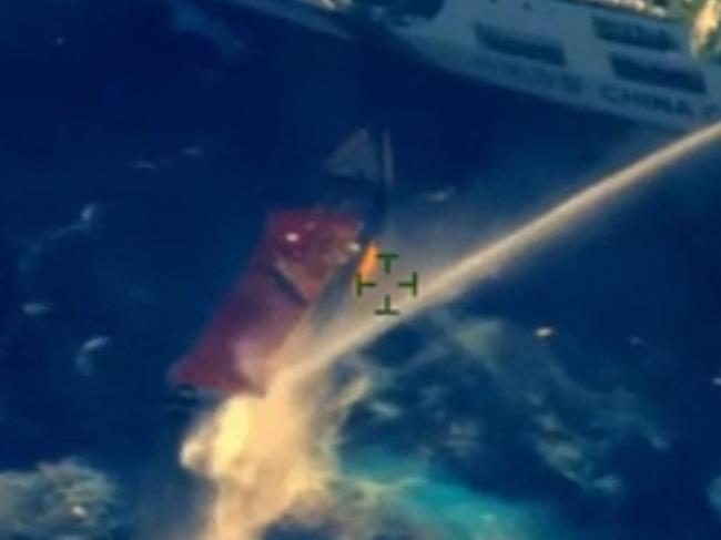 This frame grab from handout aerial video footage taken and released on March 23, 2024 by the Armed Forces of the Philippines shows a China Coast Guard ship (top) deploying water cannon against the Philippine military-chartered civilian boat Unaizah May 4 during its supply mission near the Second Thomas Shoal in disputed waters of the South China Sea. The Philippines accused the China Coast Guard of blocking and firing water cannon at a Filipino supply vessel on March 23 off a remote and contested South China Sea reef. (Photo by Handout / ARMED FORCES OF THE PHILIPPINES / AFP) / RESTRICTED TO EDITORIAL USE - MANDATORY CREDIT "AFP PHOTO /  ARMED FORCES OF THE PHILIPPINES" - NO MARKETING - NO ADVERTISING CAMPAIGNS - DISTRIBUTED AS A SERVICE TO CLIENTS
