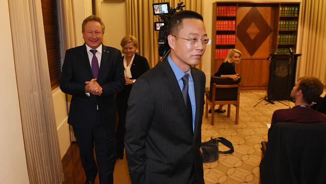 Long Zhou (centre) departs the press conference with Andrew Forrest behind him. Picture: AAP.