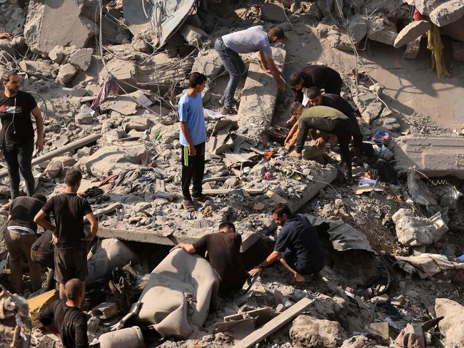 People search for victims and survivors through the rubble of a building destroyed in an Israeli strike on the Bureij refugee camp in the central Gaza Strip. Picture: AFP