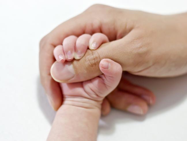 Hands of a newborn baby with the nails, holding his mothers hand.  CREDIT istock image