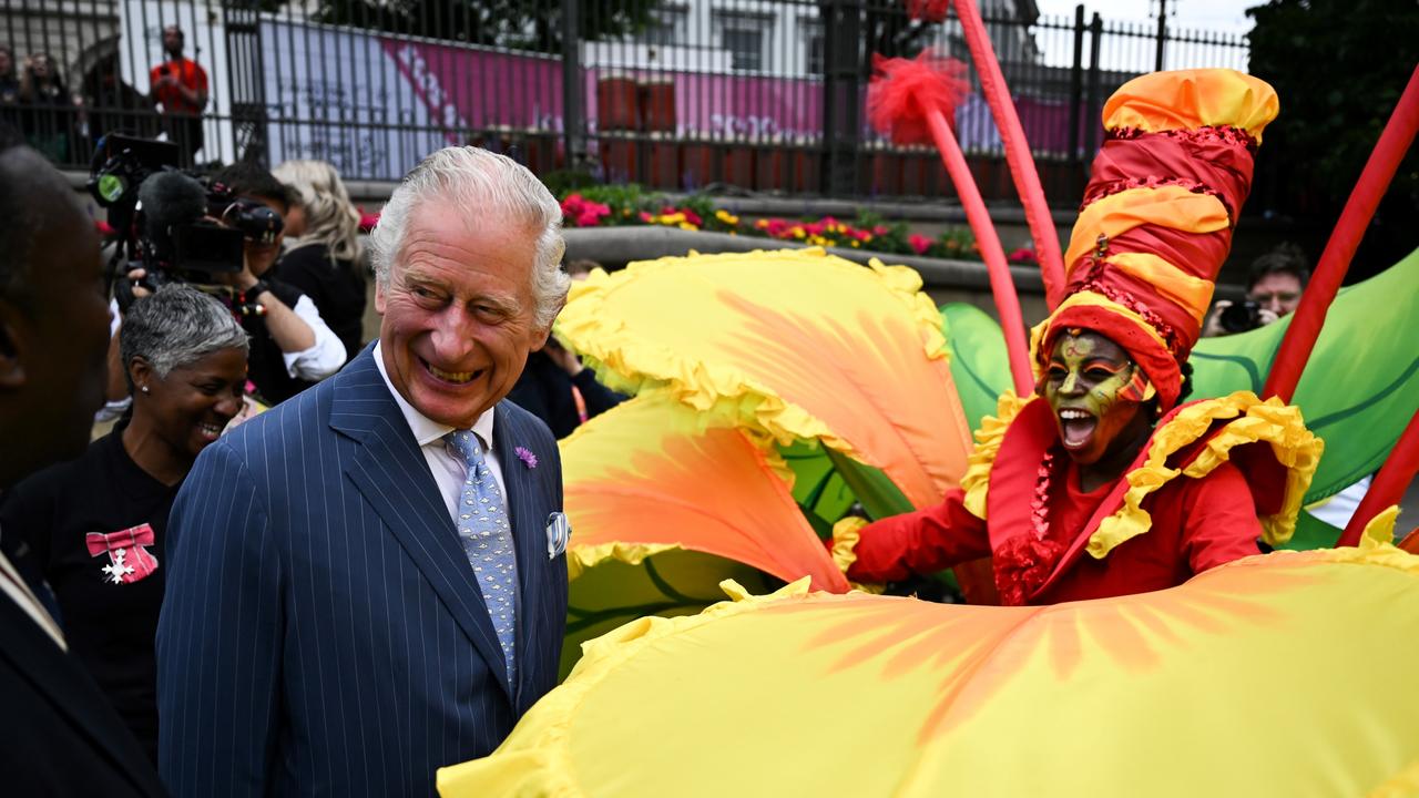 Britain's Prince Charles, Prince of Wales reacts as he speaks with a performer