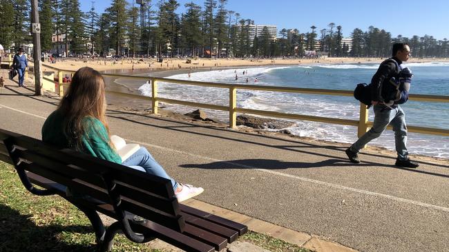 A public bench, with a memorial plaque for a deceased person attached, on Marine Pde, overlooking Manly Beach. Picture: Jim O’Rourke