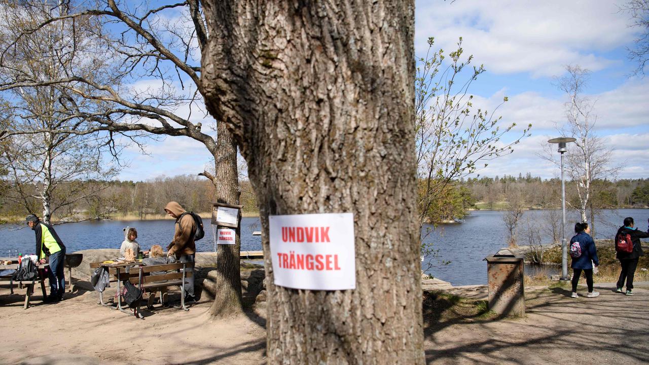 A sign on a tree reads ‘avoid congestion’ at the popular recreational area Hellasgarden in the outskirts of Stockholm. Picture: AFP