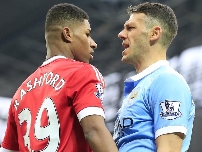 United’s Marcus Rashford (L) and Manchester City's Martin Demichelis.