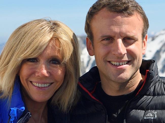 French presidential election candidate for the En Marche ! movement Emmanuel Macron (R) and his wife Brigitte Trogneux pose during a campaign visit in Bagneres de Bigorre on April 12, 2017. / AFP PHOTO / POOL