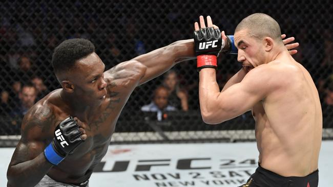 Israel Adesanya lands on Robert Whittaker during their first title fight at UFC 243. Photo by Jeff Bottari/Zuffa LLC/Zuffa LLC via Getty Images