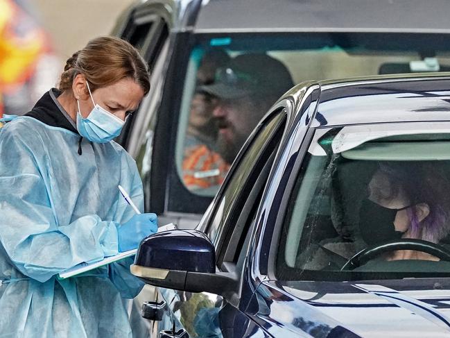 A medical worker takes a sample from a person at a drive-through COVID-19 pop-up testing clinic at the Keilor Community Hub in Melbourne, Sunday, May 31, 2020. A coronavirus cluster in Melbourne's northwest has infected 13 people across two homes, closed two schools and forced more than 100 students to self-isolate. (AAP Image/Scott Barbour) NO ARCHIVING