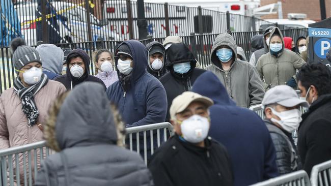 Patients wear personal protective equipment while maintaining social distancing as they wait in line for a COVID-19 test outside a New York hospital. Picture: AP